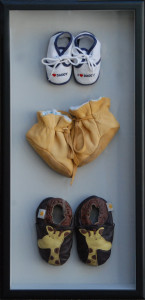 Shadow box of baby's first year of shoes